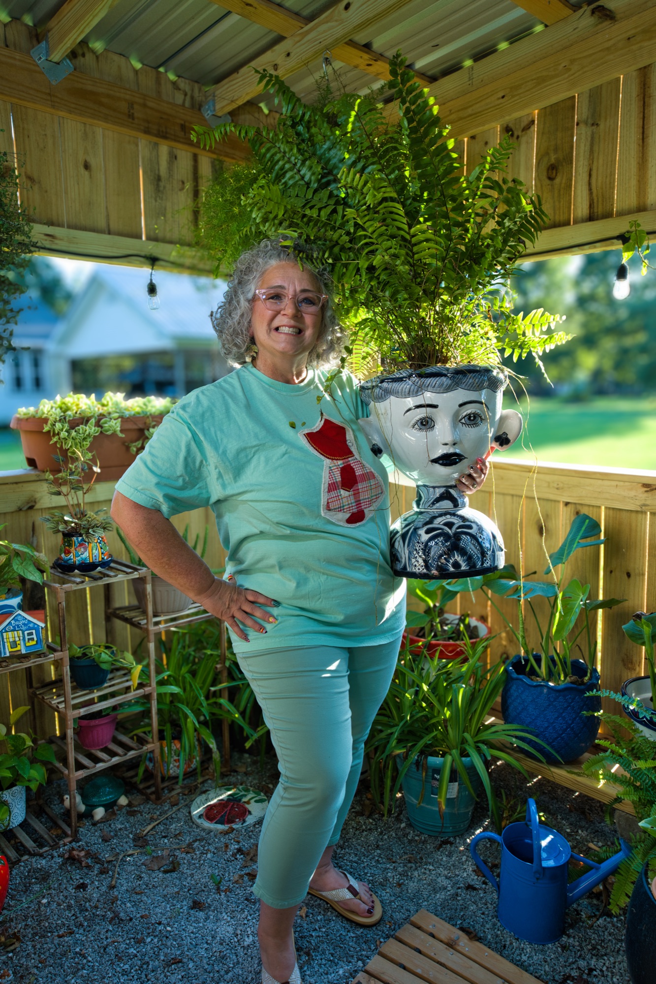 Angela inside the Plant Palace holding a big face planter overflowing with fern