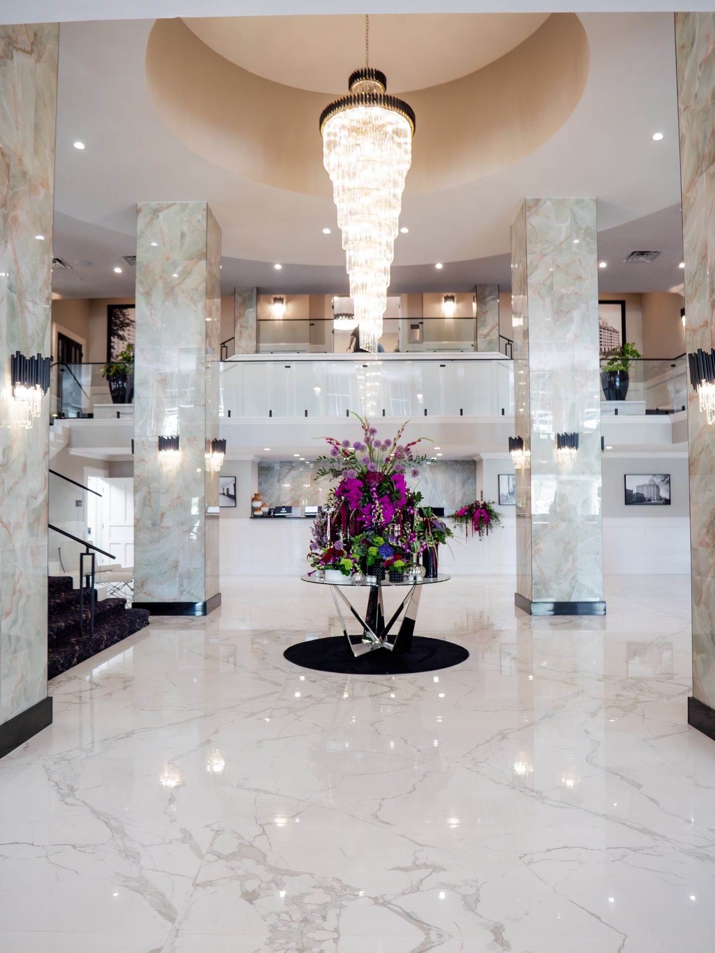The marble lobby of the Markham Hotel, with a crystal chandelier above a tall arrangement of purple and pink flowers